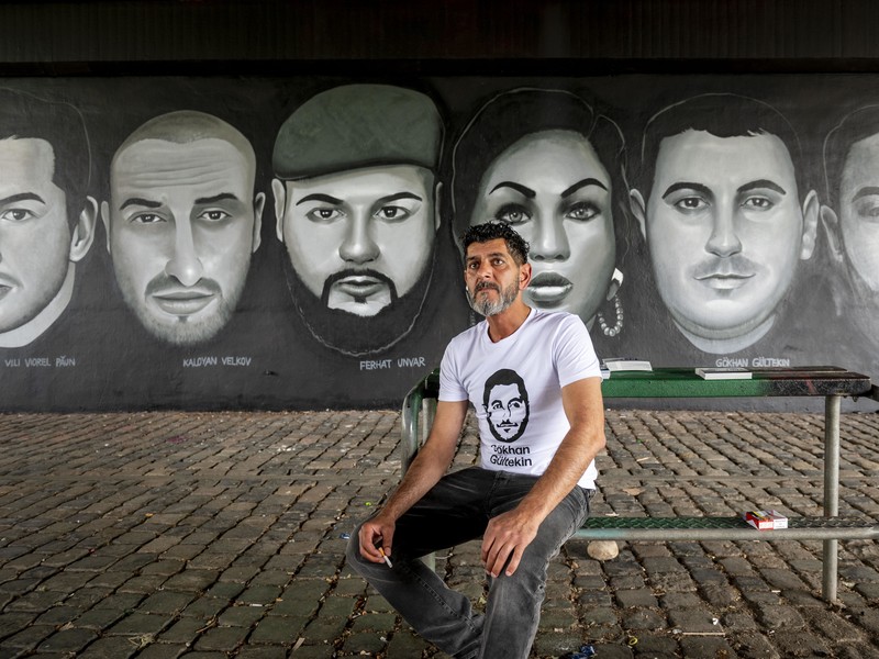 Çetin Gültekin, der Bruder von Gökhan Gültekin, vor einem Wandbild zum Gedenken an die neun Opfer des Amoklaufs von Hanau 