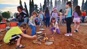 Kinder spielen am Lagerfeuer