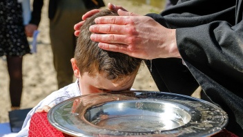 Kind wird im Strandbad Hemmingen bei Hannover getauft
