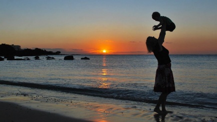 Mutter und Kind im Sonnenuntergang am Strand