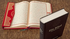 Ein aufgeschlagener Koran und eine Bibel