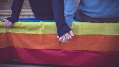 Paar sitzt auf Regenbogenflagge