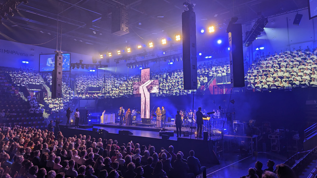 Kreuz aus LED-Bildschirmen inmitten des Publikums