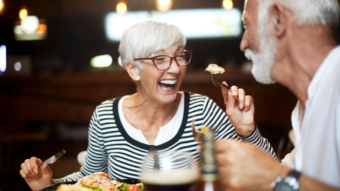 Senioren Paar genießt lachend ein Dinner zu zweit