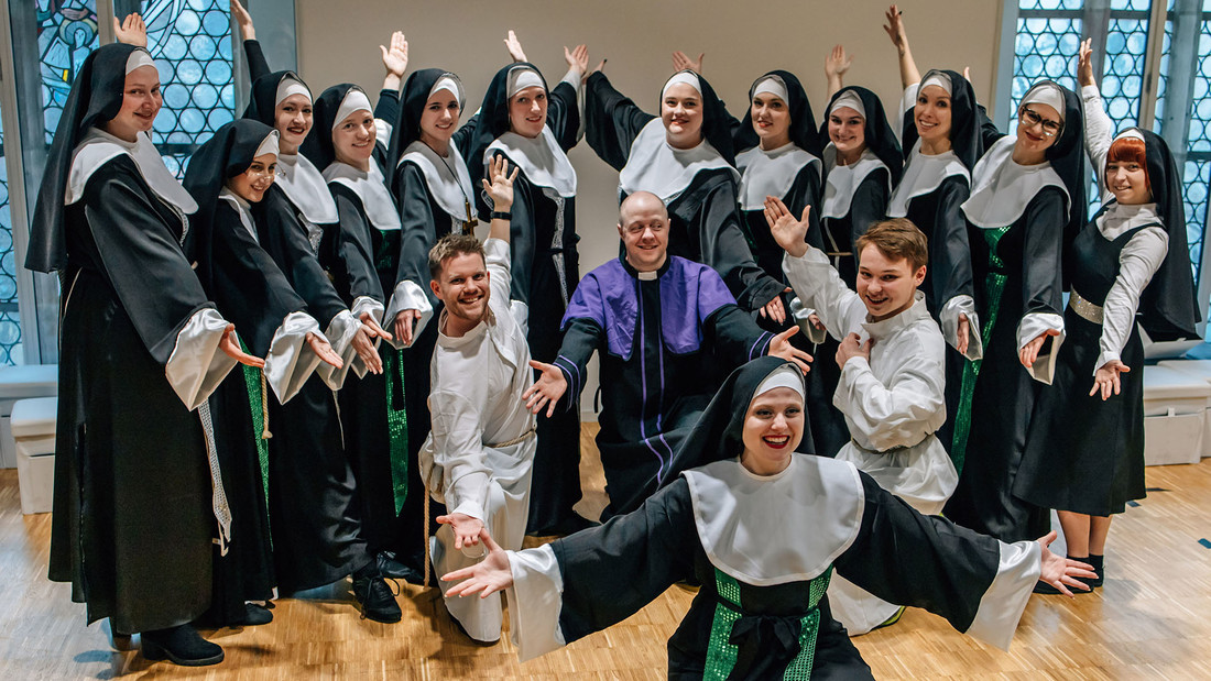 Eine Gruppe von Künstlern verkleidet als Nonnen positioniert sich zum fotografieren