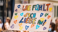Buntes Plakat mit der Aufschrift: Wie fühlt sich Liebe an