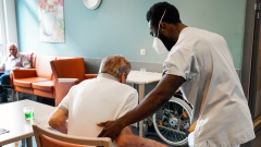 Schwarze Pflegekraft hilft in einer Senioreneinrichtung