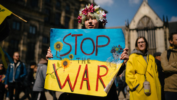 Frau trägt Protestplakat für Frieden in der Ukraine