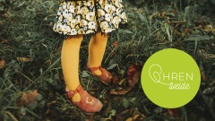 Mädchen in gelben Strumpfhosen auf Gras