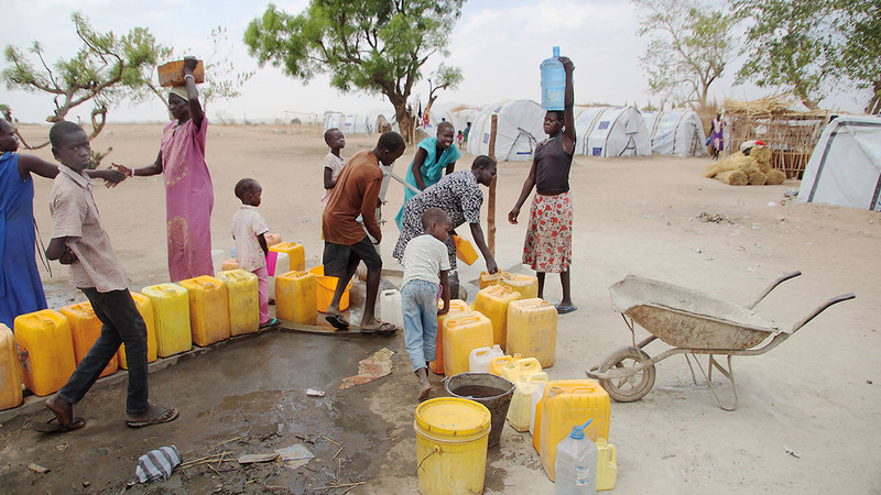 Menschen an der Wasserpumpe im Flüchtlingscamp Gumbo im Südsudan