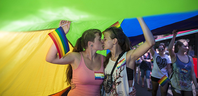CSD, Wiesbaden,  06.06.2015 CSD, Demo-Parade, Wiesbaden, im Bild: Teilnehmer der Demo-Parade in der Bahnhofstrasse, zwei junge Frauen küssen sich, Regenbogenfahne / Regenbogen-Fahne, 