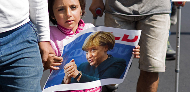 Ein Mädchen in Budapest trägt ein Bild der deutschen Bundeskanzlerin Angela Merkel. 