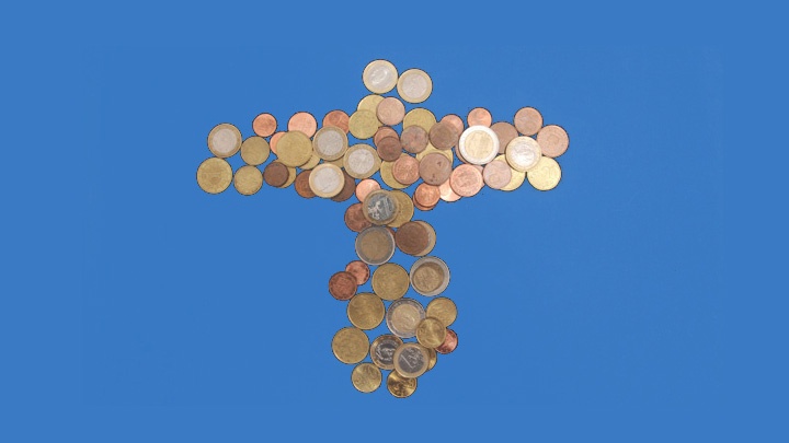 Verschiedene Münzen bilden ein Kreuz auf blauem Untergrund.