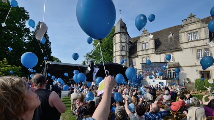 Zum ökumenischen Kirchentag lassen Menschen Luftballons steigen.
