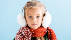 Kind mit Ohrenwärmern und Schal