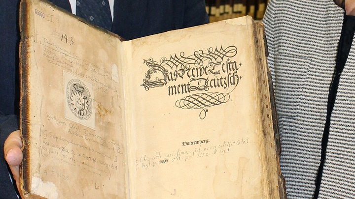 Der Kieler Kirchenhistoriker Johannes Schilling und Klara Erdei, Leiterin des Altbestandes der Kieler Uni-Bibliothek, mit einem Original-Exemplar des September-Testaments von Martin Luther.