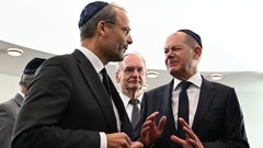 Bundeskanzler Olaf Scholz (r, SPD) spricht mit Felix Klein, Beauftragter der Bundesregierung für jüdisches Leben in Deutschland und den Kampf gegen Antisemitismus, dazwischen steht Reiner Haseloff (CDU).