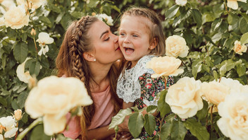 Mutter und Tochter sitzen im Garten und haben Spaß.