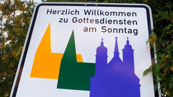 Schild mit Kirchensymbolen für Gottesdienste 