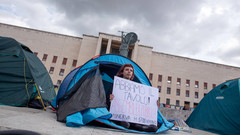 Eine Studentin gibt in Rom eine öffentliche Versammlung zum Thema "Hohe Mieten" bekannt.