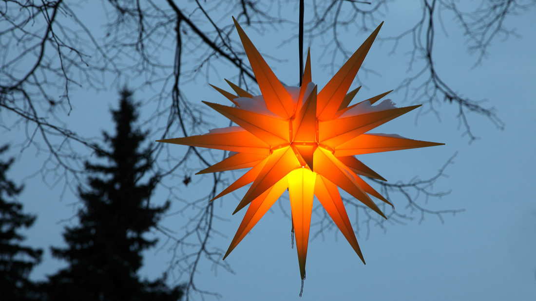 Ein Herrnhuter stern leuchtet am Abendhimmel