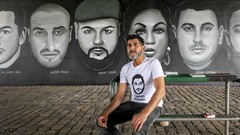Çetin Gültekin, der Bruder des ermordeten Gökhan Gültekin, vor einem Wandbild zum Gedenken an die neun Opfer des Amoklaufs von Hanau