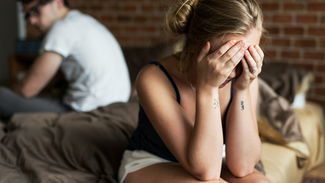 Unglückliches Ehepaar sitzt auf Bett