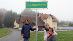 Pastor Roland Lachenmann mit Frau und Sohn vor dem Ortschild von Bethlehem im Kreis Sigmaringen