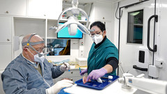 Ein Zahnarzt und eine Zahnarzthelferin arbeiten an eine Zahnprotese.