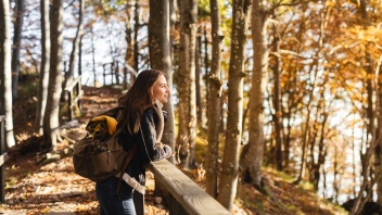 Frau genießt die Aussicht im Herbstwald