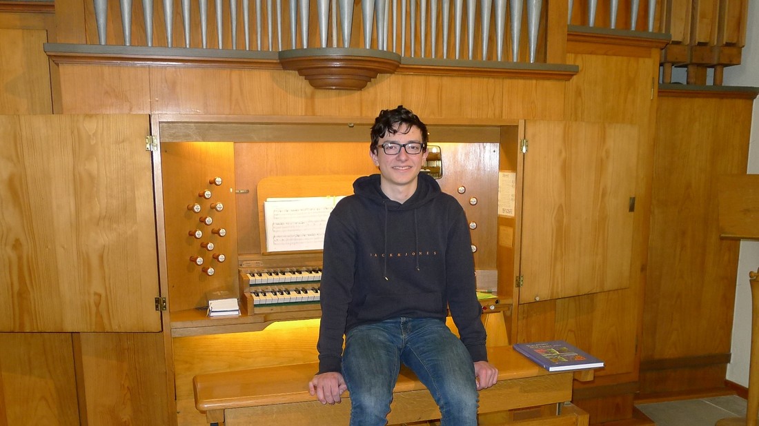 Junger Mann sitzt auf Orgel