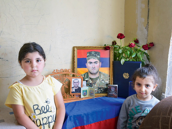 Zwei Mädchen (in Jerewan) vor dem Foto ihres verstorbenen Vaters Er ist im Krieg zwischen Armenien und Aserbaidschan gestorben. In Bergkarabach sind Tausende Menschen dem Hunger ausgesetzt