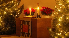 Altar mit beleuchteten Weihnachtsbäumen an der Seite