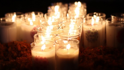 Ein Kreuz aus brennenden Kerzen