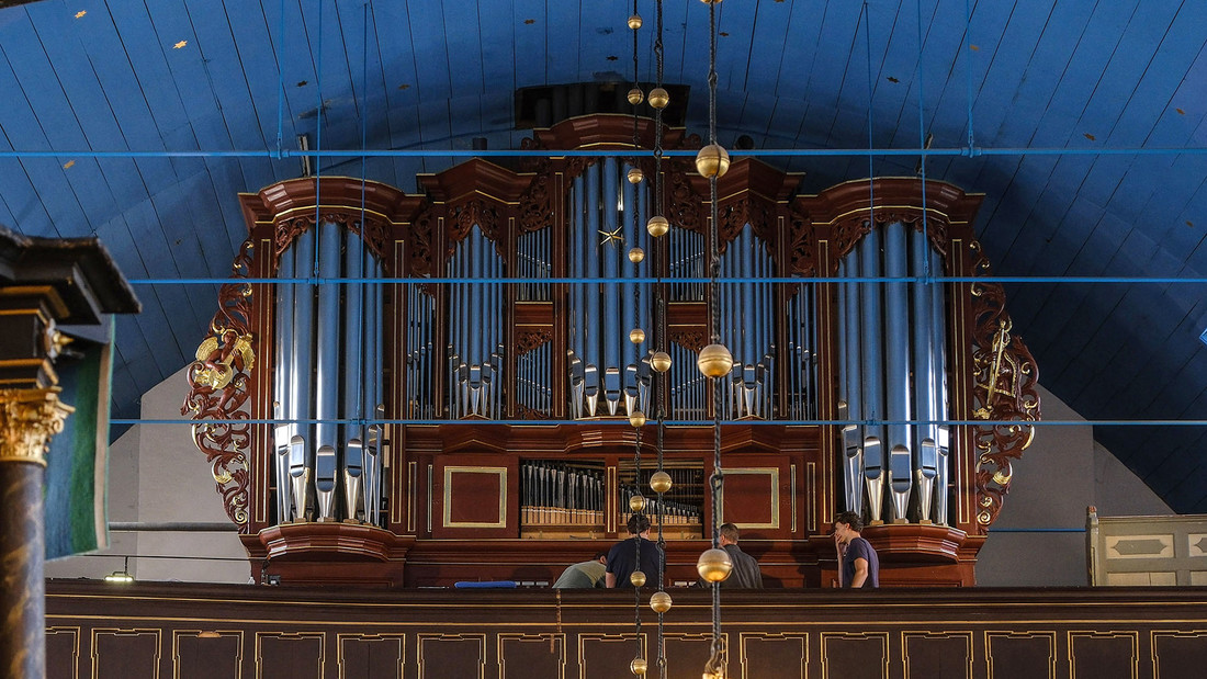 Eine historische Orgel steht auf der Empore einer Kirche.