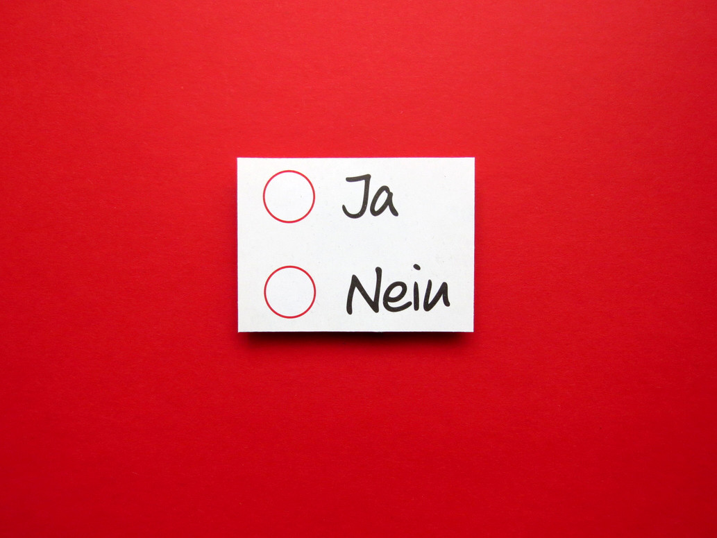 Ein Zettel mit den Antworten "Ja" und "Nein" hängt an einer roten Wand