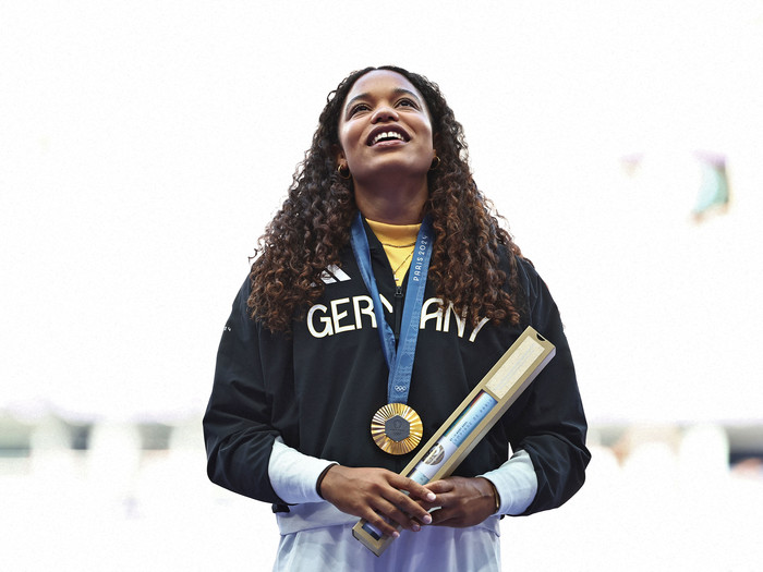 Die deutsche Goldmedaillengewinnerin Yemisi Ogunleye steht auf dem Podium während der Siegerehrung des Kugelstoßfinales der Frauen bei den Olympischen Spielen Paris 2024 im Stade de France in Saint-Denis, nördlich von Paris, am 10. August 2024