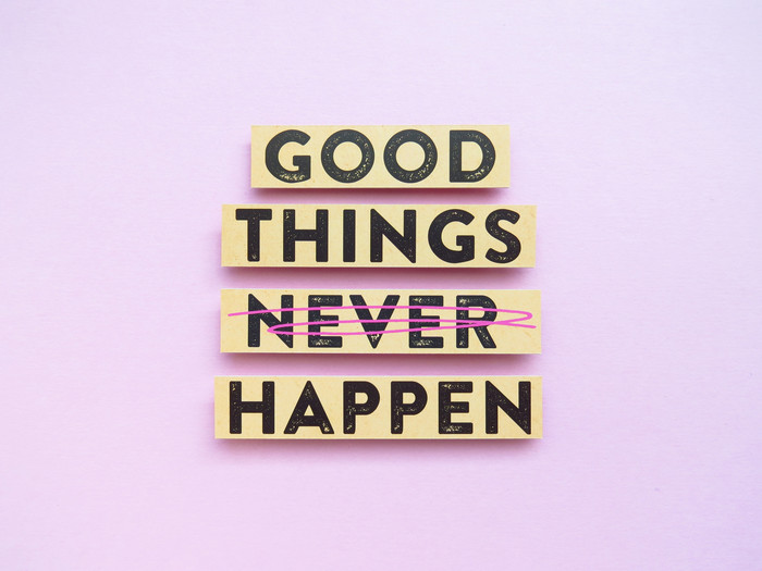 Der Satz 'Good things never happen' steht auf rosa Hintergrund geschrieben. Das Wort 'never' ist druchgestrichen