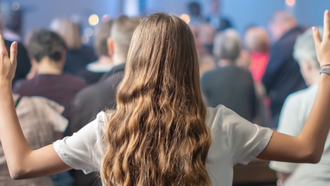 Jugendliche mit erhobenen Händen in Kirche