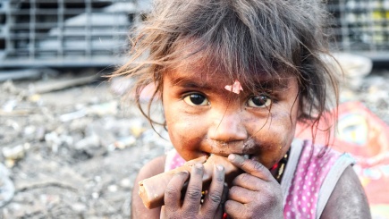 Mädchen in den Slums isst Brotreste