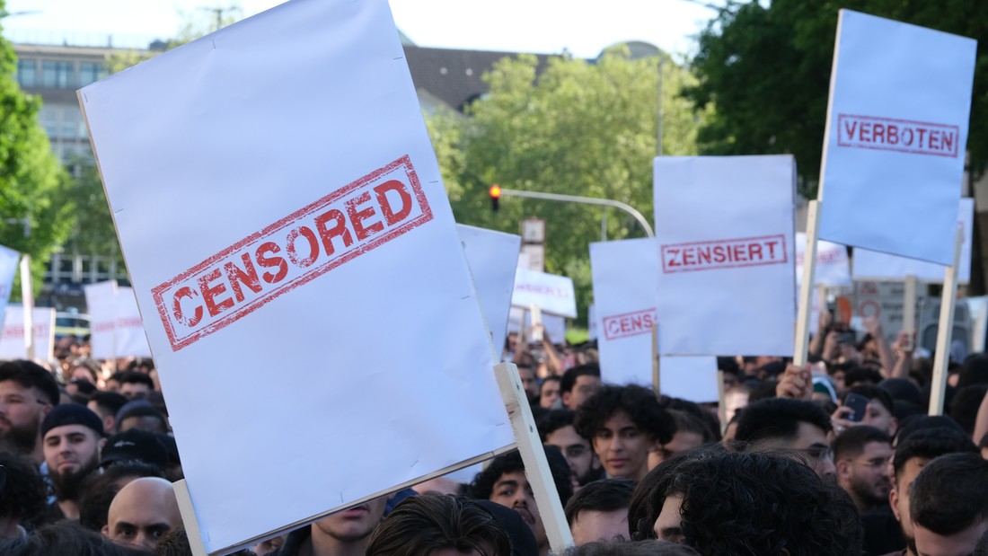 Demonstrierende halten Plakate mit der Aufschrift "Verboten" hoch