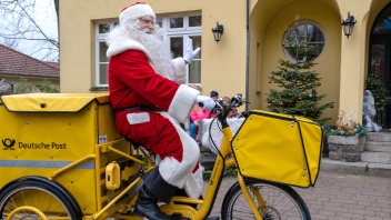 Weihnachtsmann auf Post-Fahrrad