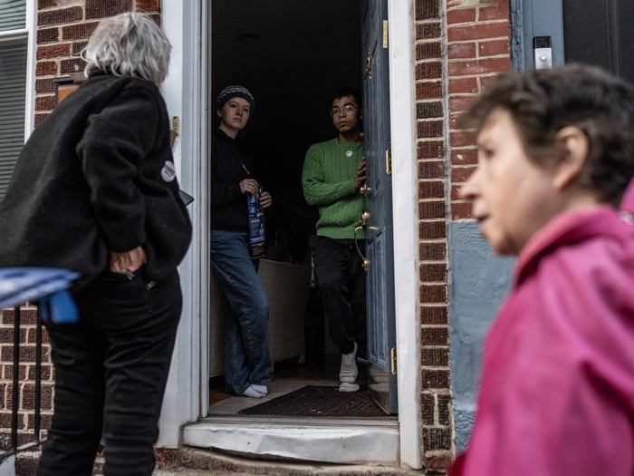 Kamala Harris' Wahlkampfhelferinnen Vickie M. Feldman (R) und Kate Esposito sprechen mit zwei Personen über Wahllokale und Regeln während einer "Get Out The Vote"-Aktion zwei Tage vor dem Wahltag in Philadelphia, Pennsylvania, am 3. November 2024