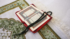 Aufgeschlagener Koran mit Gebetskette in Moschee