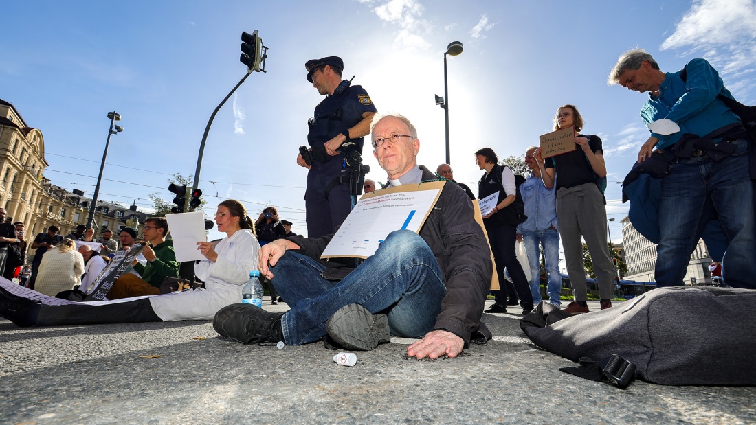 Klimaaktivisten, u.a. Nürnberger Jesuitenpater Jörg Alt auf der Straße