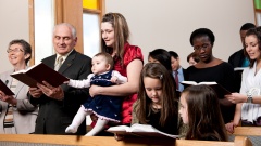 Familie Opa, Mutter und Baby  und Kindern im Gottesdienst