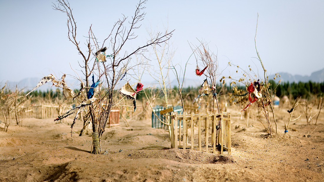 Gräberfeld muslimischer Uiguren in der Provinz Xinjiang. Die bunten Fähnchen an den Zweigen markieren Gebete oder Wünsche der Hinterbliebenen