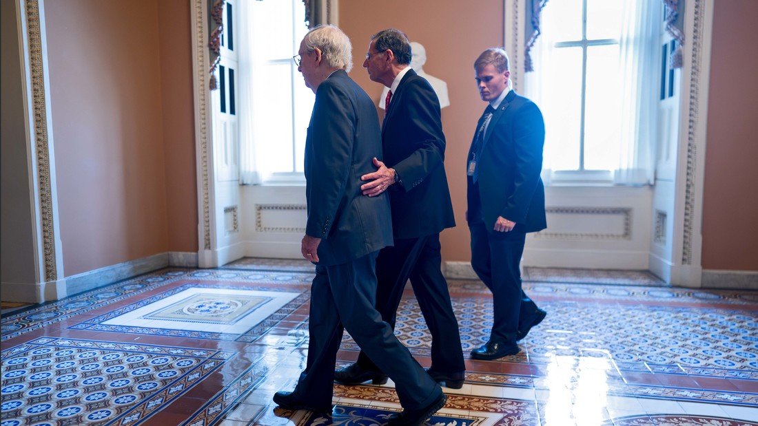 Der US-Politiker Mitch McConnell (links) wird am 26. Juli 2023 in sein Büro begleitet. Zuvor war der 81-jährige während einer Pressekonferenz vor den Mikrofonen erstarrt. 