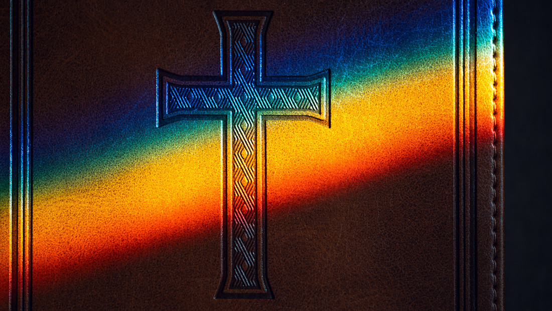 Kreuz vor Regenbogenfarben