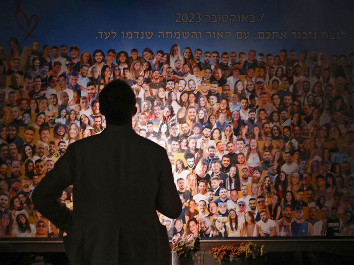 A person views a collage as relatives and supporters of Israeli hostages, taken by Palestinian militants during the October 7 Hamas attack